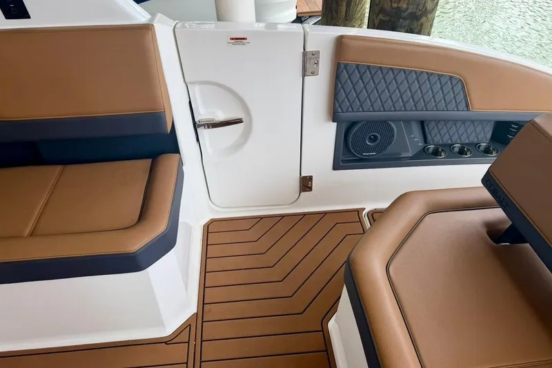 Slide: The Image of Interior of 2025 Cobalt R33 boat with brown seating and wood-patterned flooring. - 33