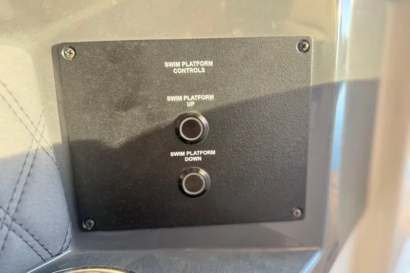 Slide: The Image of Control panel for swim platform on 2025 Cobalt R33 boat, featuring up and down buttons. - 35