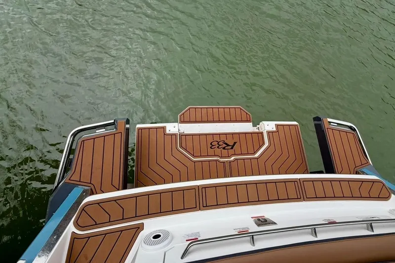Slide: The Image of 2025 Cobalt R33 boat with teak deck on calm water. - 37