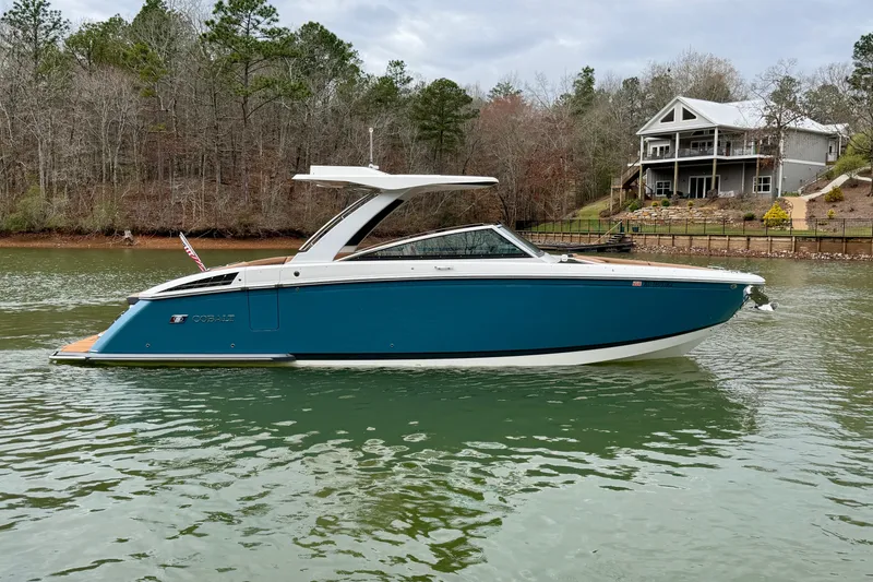 Slide: The Image of 2025 Cobalt R33 boat on a serene lake with a house in the background. - 4