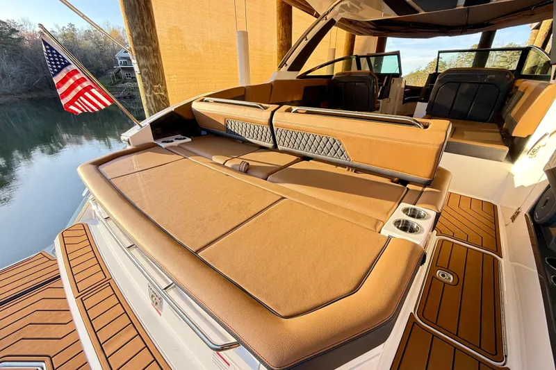 Slide: The Image of Luxurious 2025 Cobalt R33 boat interior with tan seating and American flag. - 8