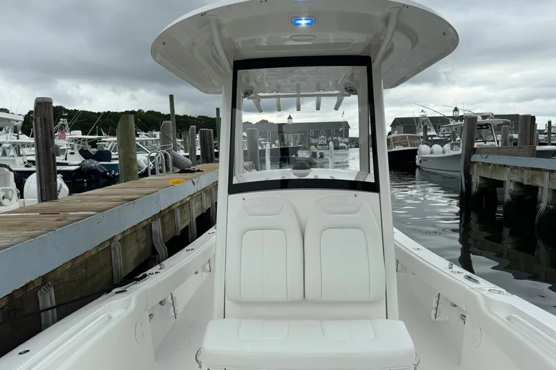 Slide: The Image of 2025 Regulator 24XO boat docked at marina under cloudy skies. - 24