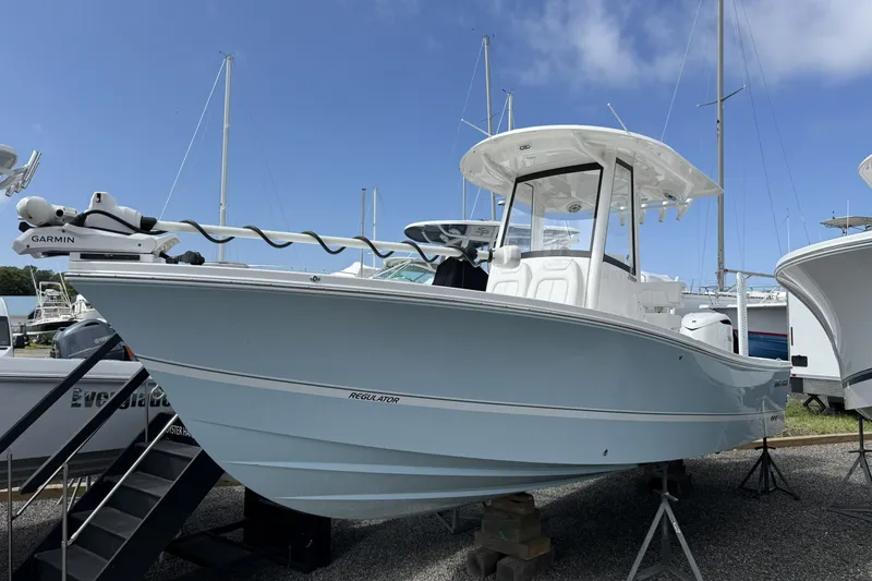 The Image of 2025 Regulator 24XO boat displayed on stands, featuring Garmin equipment, under a clear blue sky. - 0