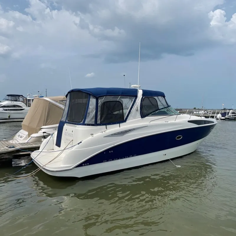 The Image of 2007 Bayliner 325 boat docked in marina, featuring blue and white exterior. - 0
