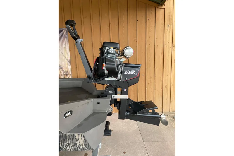 Slide: The Image of 2026 Reaper Boats 753 Timber Reaper motor, mounted on a wooden dock background. - 2