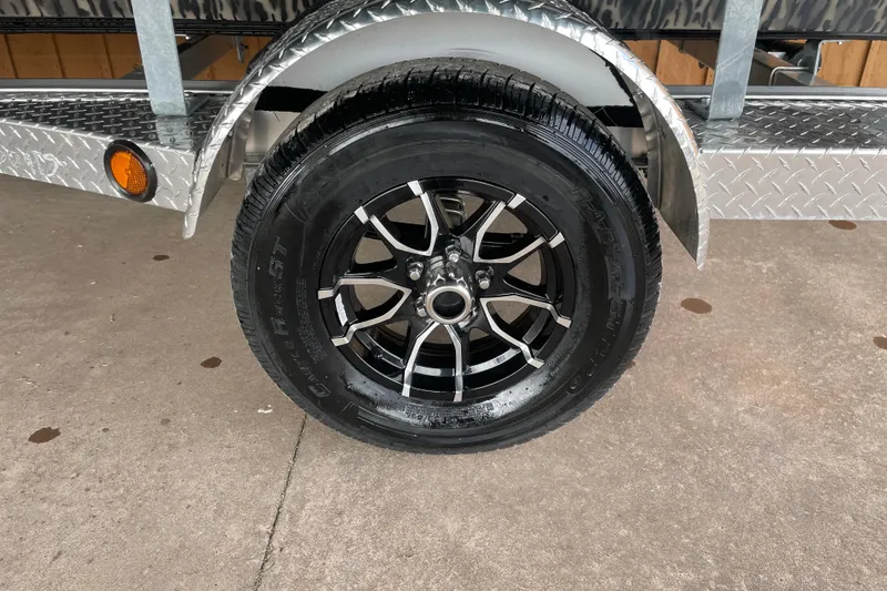 Slide: The Image of Trailer wheel of 2026 Reaper Boats 753 Timber Reaper, featuring sleek black alloy rims. - 8