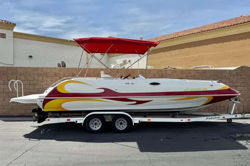 The Image of 2000 Godfrey 248 Fundeck boat with red and yellow design on a trailer. - 0