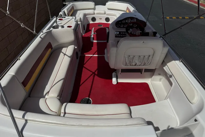 Slide: The Image of Interior of a 2000 Godfrey 248 Fundeck boat with red carpet and white seating. - 12