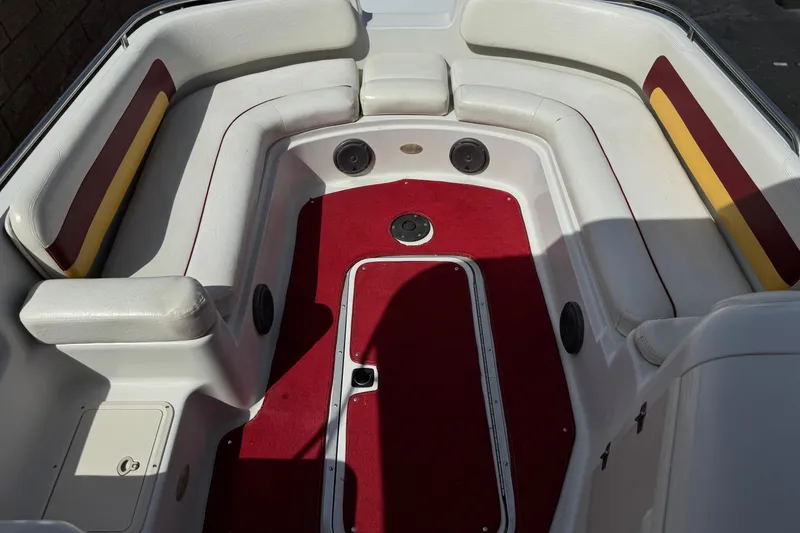 Slide: The Image of Interior of a 2000 Godfrey 248 Fundeck boat with red carpet and white seating. - 13