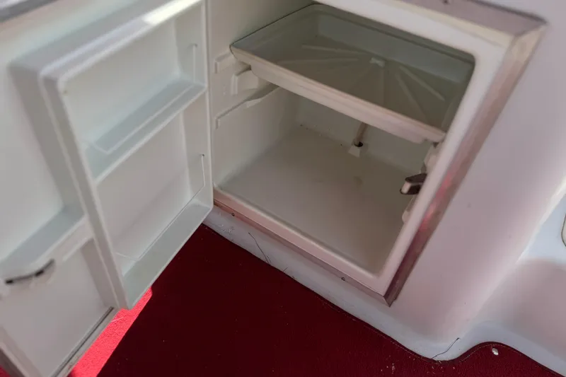 Slide: The Image of Open storage compartment on 2000 Godfrey 248 Fundeck boat with red carpet flooring. - 20