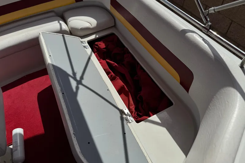 Slide: The Image of Open storage compartment on 2000 Godfrey 248 Fundeck boat with red fabric inside. - 23