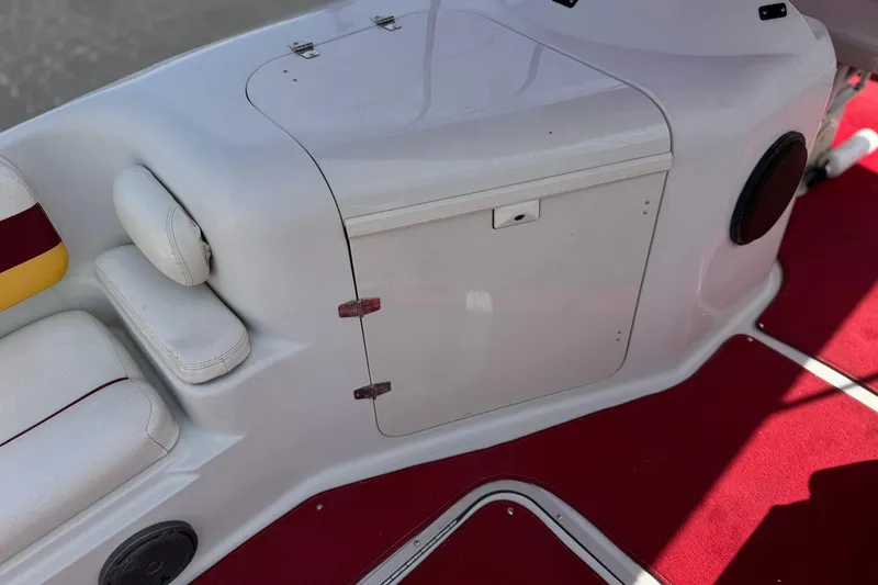 Slide: The Image of Interior of a 2000 Godfrey 248 Fundeck boat with white seating and red carpet. - 28