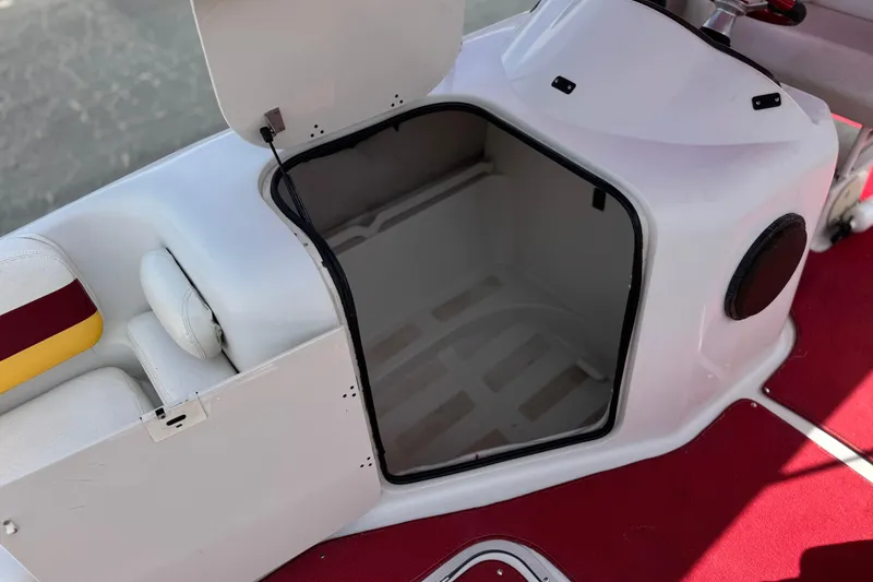 Slide: The Image of Open storage compartment on a 2000 Godfrey 248 Fundeck boat with red carpet. - 29
