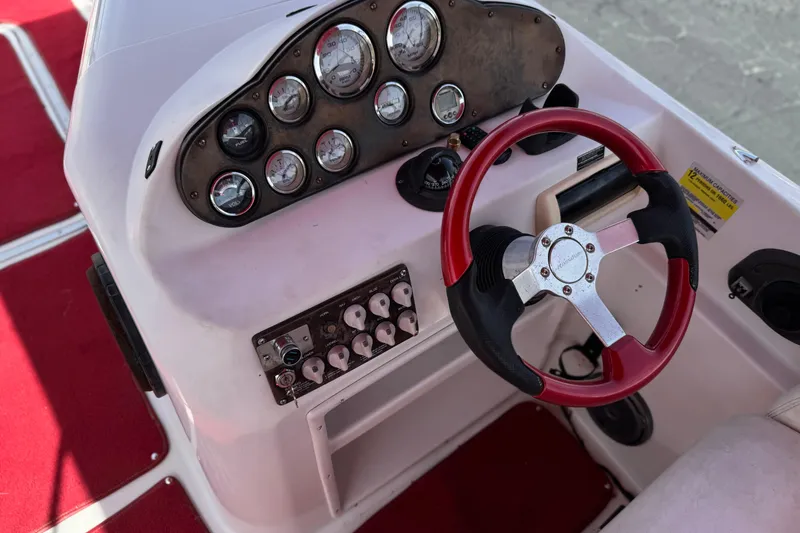 Slide: The Image of Dashboard of a 2000 Godfrey 248 Fundeck boat with red steering wheel. - 33
