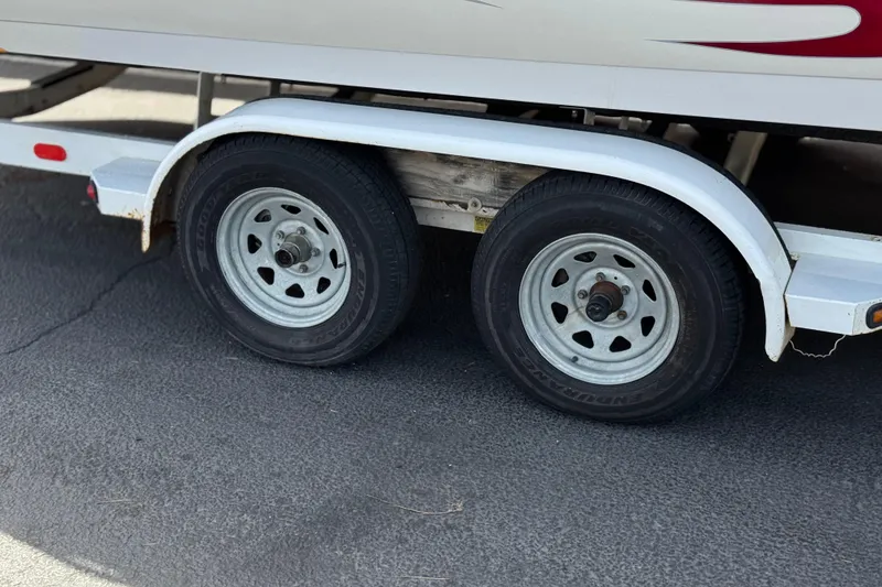 Slide: The Image of Trailer wheels of a 2000 Godfrey 248 Fundeck boat on pavement. - 35