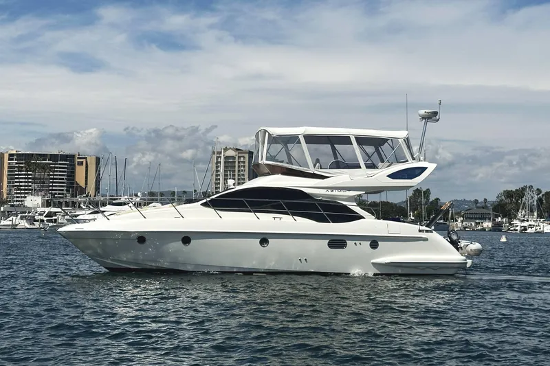 The Image of 2007 Azimut 43 yacht cruising in a marina with cityscape background. - 0