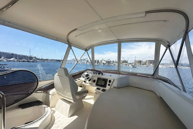 Slide: The Image of Interior view of 2007 Azimut 43 yacht helm with marina backdrop. - 10