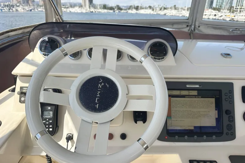 Slide: The Image of Steering wheel and dashboard of a 2007 Azimut 43 yacht, featuring navigation instruments. - 11