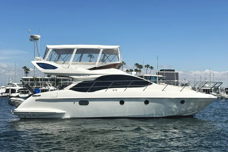 Slide: The Image of 2007 Azimut 43 yacht docked in a marina under clear blue skies. - 2