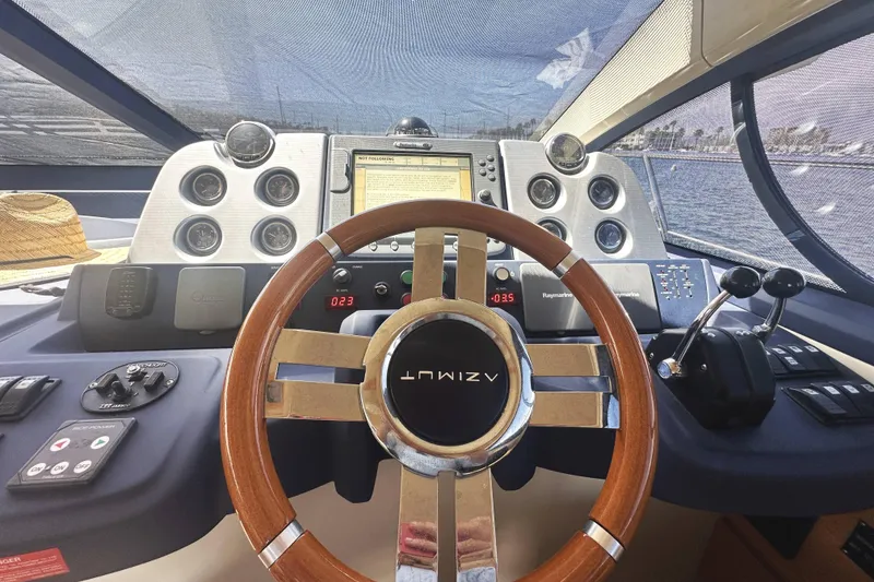 Slide: The Image of Cockpit view of 2007 Azimut 43 yacht with wooden steering wheel and navigation controls. - 24