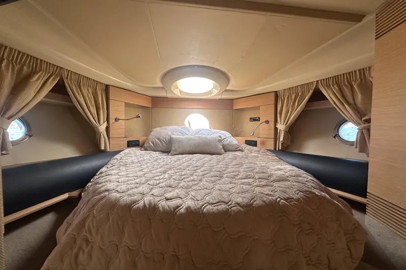 Slide: The Image of Luxurious bedroom interior of 2007 Azimut 43 yacht with elegant bedding and porthole windows. - 35