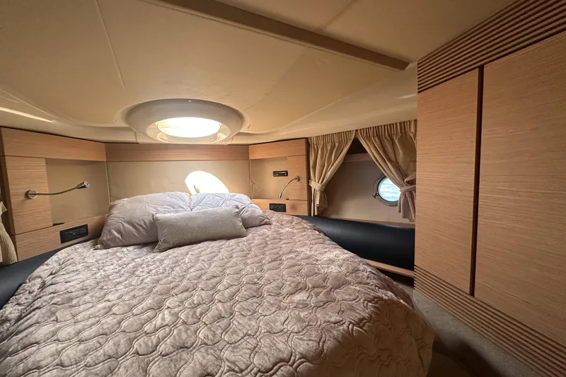 Slide: The Image of Luxurious bedroom interior of 2007 Azimut 43 yacht with elegant bedding and porthole window. - 36