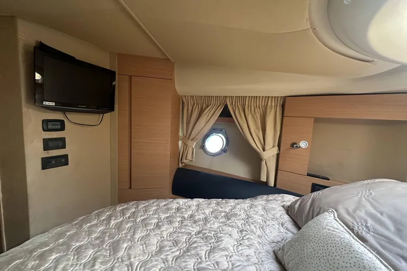 Slide: The Image of Luxurious cabin interior of a 2007 Azimut 43 yacht with cozy bedding and a porthole. - 37