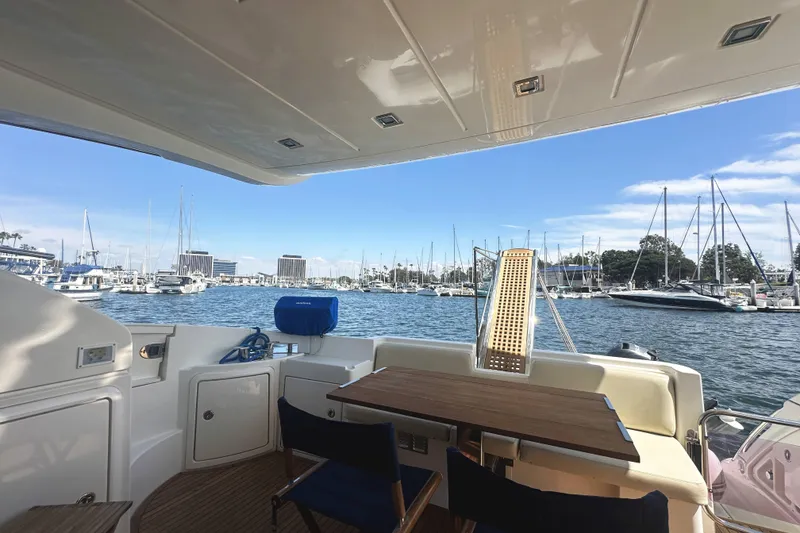 Slide: The Image of 2007 Azimut 43 yacht interior with marina view, featuring a wooden table and seating. - 7