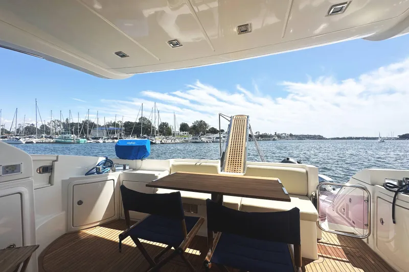 Slide: The Image of 2007 Azimut 43 yacht interior with marina view, featuring seating and table setup. - 8