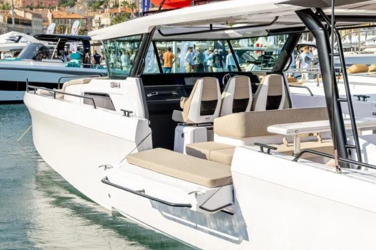 Slide: The Image of 2027 Axopar 45 Cross Top luxury boat docked at marina, showcasing sleek design and seating. - 4
