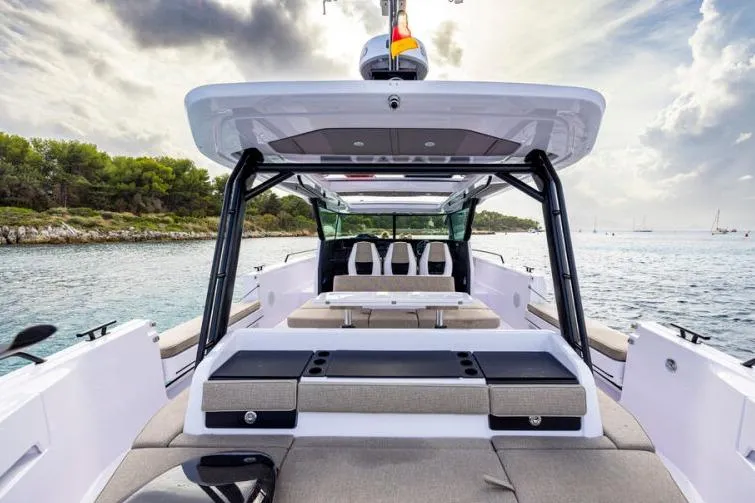 Slide: The Image of 2027 Axopar 45 Cross Top boat on serene water with modern seating and canopy. - 5