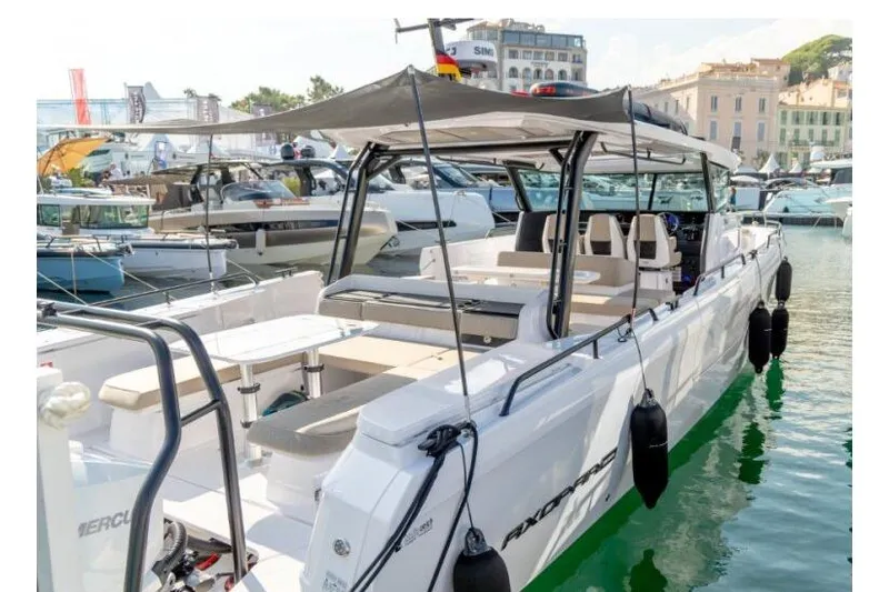 Slide: The Image of 2027 Axopar 45 Cross Top boat docked at marina, showcasing sleek design and spacious seating. - 6