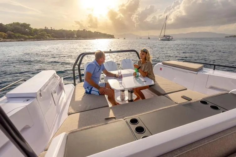 Slide: The Image of Couple enjoying sunset on 2027 Axopar 45 Cross Top boat, with scenic ocean view. - 8