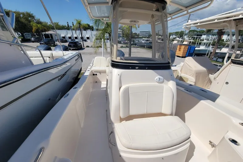 Slide: The Image of 2017 Grady-White 251 Coastal Explorer boat interior with seating and console, docked outdoors. - 17