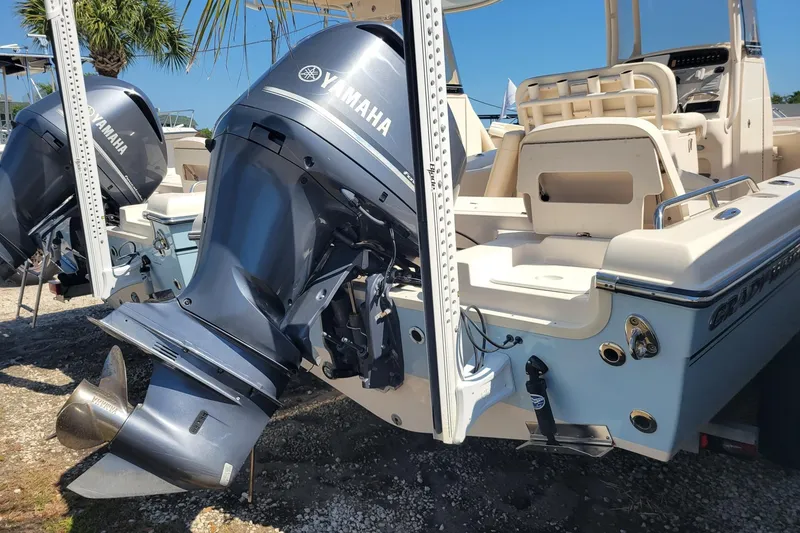 Slide: The Image of 2017 Grady-White 251 Coastal Explorer boat with Yamaha outboard engines, docked under palm trees. - 2