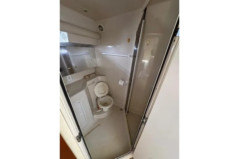 Slide: The Image of 1999 Cruisers 3870 Express yacht bathroom with toilet and shower area. - 16