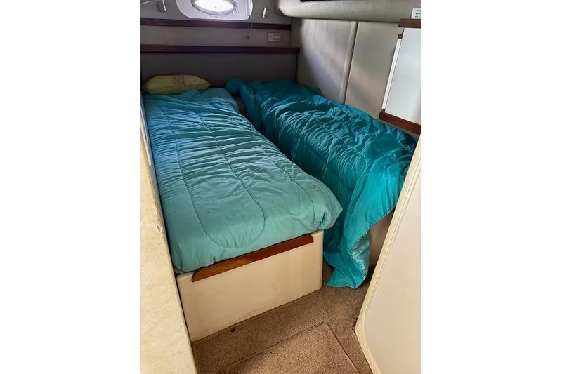 Slide: The Image of Twin beds in the 1999 Cruisers 3870 Express cabin with teal bedding. - 18