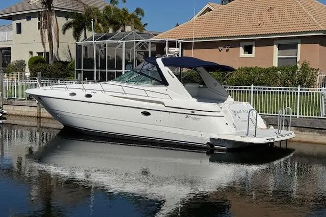 Slide: The Image of 1999 Cruisers 3870 Express yacht docked by waterfront homes. - 4