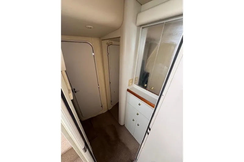 Slide: The Image of Interior of 1999 Cruisers 3870 Express yacht, featuring hallway with cabinets and doors. - 20