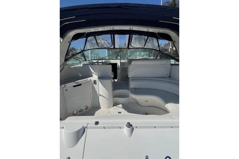 Slide: The Image of 1999 Cruisers 3870 Express yacht interior with white seating and helm. - 6