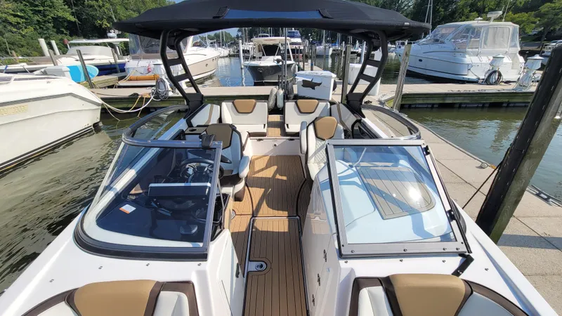 Slide: The Image of 2021 Yamaha Boats 252SD with sleek design, spacious seating, and modern features docked at a marina. - 14