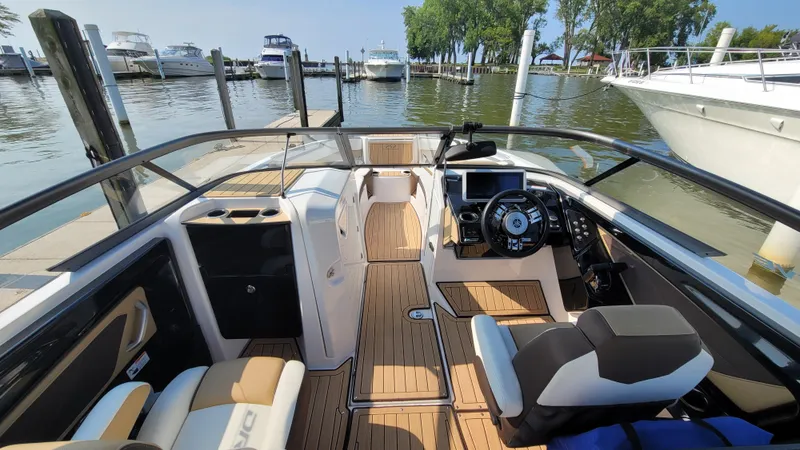 Slide: The Image of 2021 Yamaha Boats 252SD interior with sleek design, docked at marina. - 19