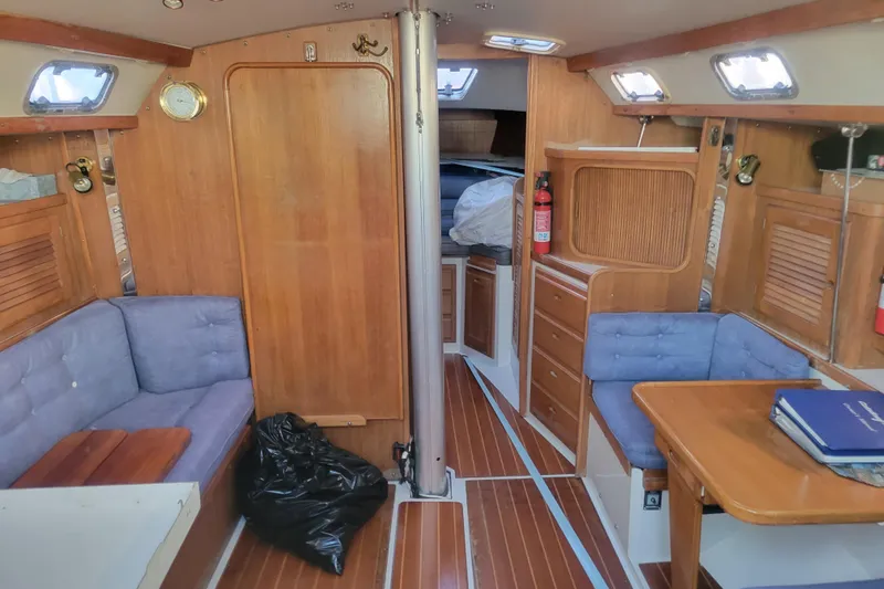 Slide: The Image of Interior of a 1996 Catalina 36 MkII sailboat with wood paneling and blue seating. - 14