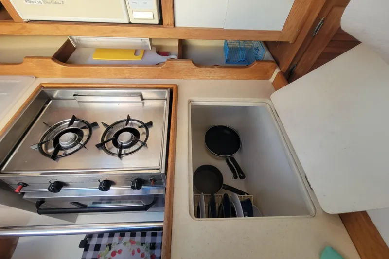 Slide: The Image of Compact kitchen area in a 1996 Catalina 36 MkII sailboat with stove and storage. - 19