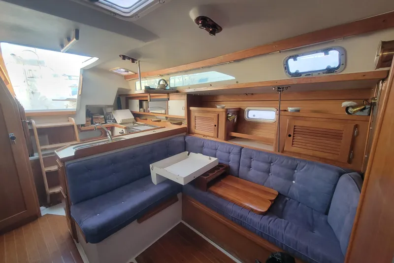 Slide: The Image of Interior of a 1996 Catalina 36 MkII sailboat with wooden cabinetry and blue seating. - 25