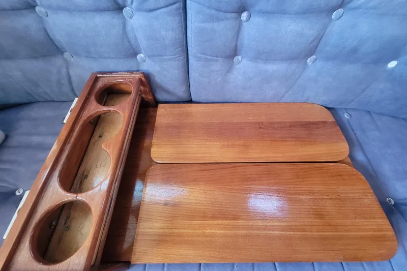 Slide: The Image of Wooden table and cup holder from a 1996 Catalina 36 MkII yacht, on a blue cushioned seat. - 27