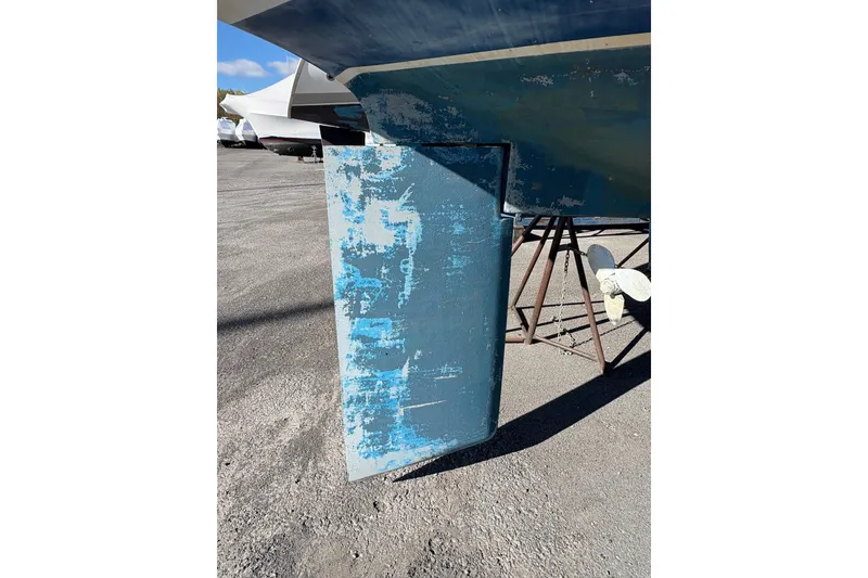 Slide: The Image of Catalina 36 MkII 1996 sailboat rudder with worn blue paint, on dry dock. - 6