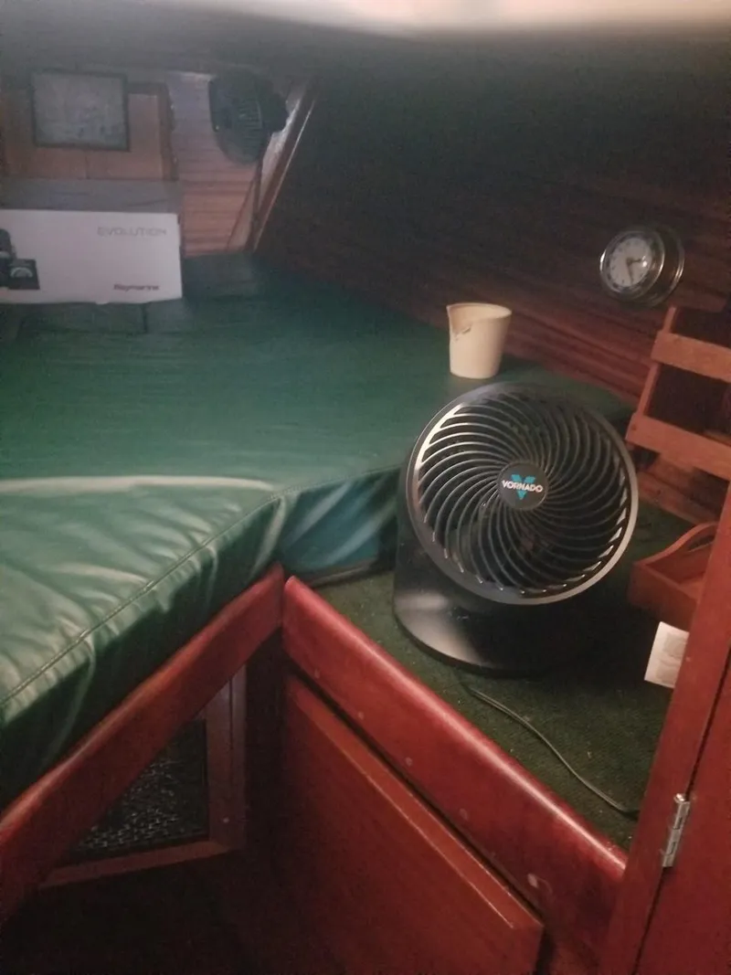 Slide: The Image of Interior cabin of a 1964 Columbia 33 sailboat with a fan and green cushions. - 13