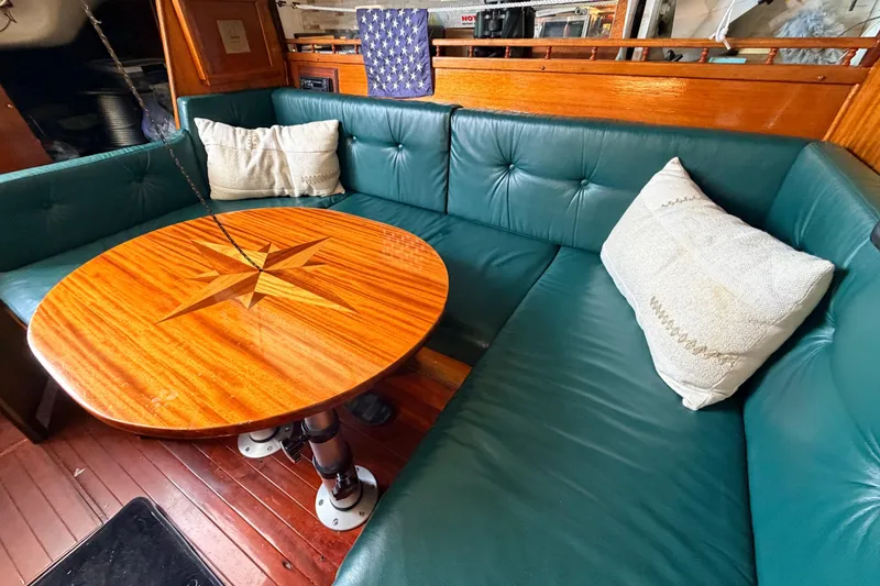 Slide: The Image of Vintage 1964 Columbia 33 yacht interior with green leather seating and wooden table. - 28