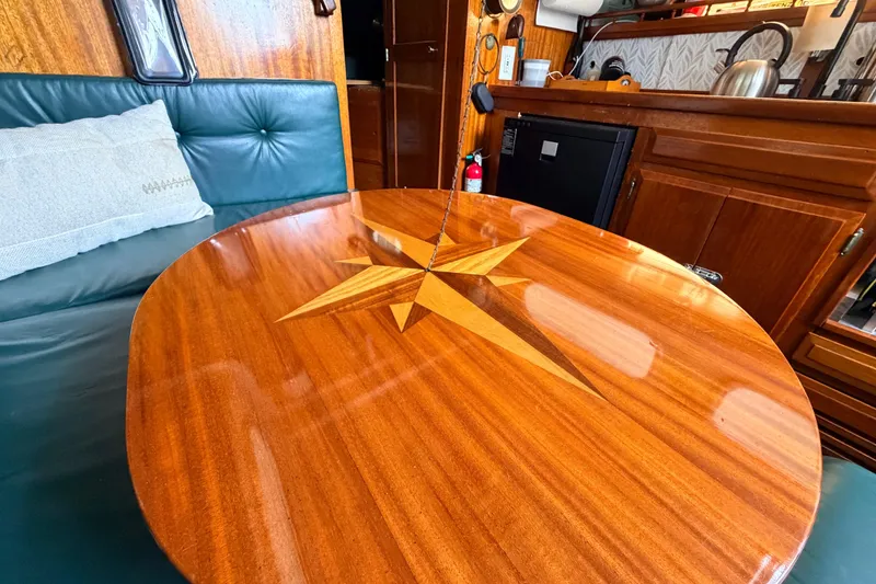 Slide: The Image of Luxurious wooden table with star inlay on a 1964 Columbia 33 yacht interior. - 32